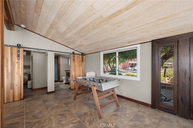 dining room with a barn door, plenty of natural light, and wood ceiling