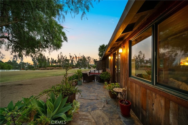 property exterior at dusk featuring a patio area