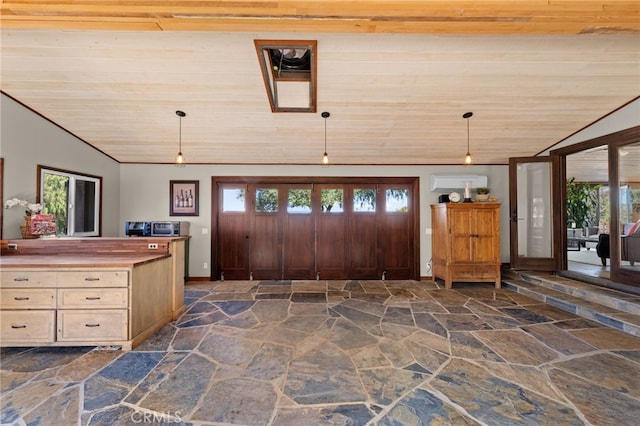 interior space with butcher block countertops, a wealth of natural light, wooden ceiling, and decorative light fixtures