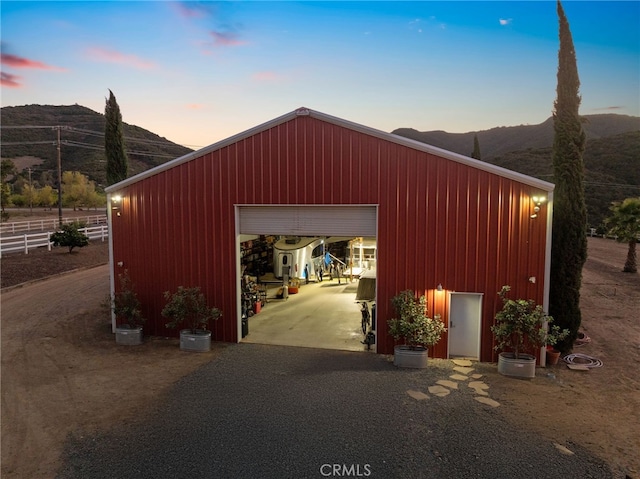 garage at dusk featuring a mountain view