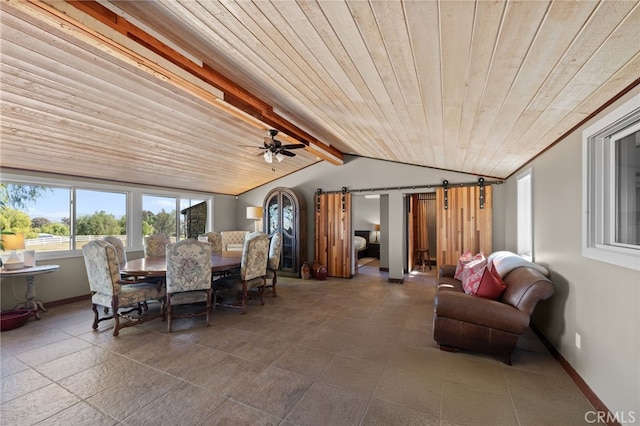 dining area featuring a barn door, lofted ceiling with beams, ceiling fan, and wooden ceiling