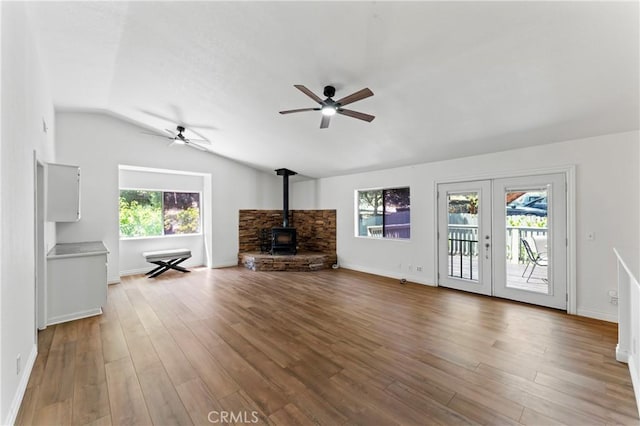 unfurnished living room with wood-type flooring, french doors, a wealth of natural light, and vaulted ceiling