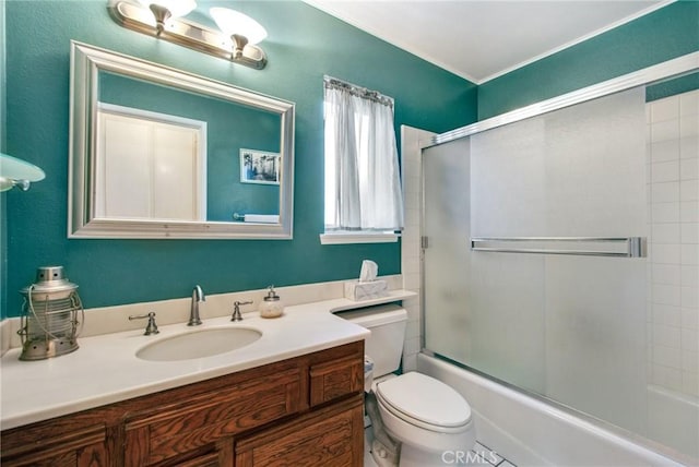 full bathroom featuring vanity, toilet, and bath / shower combo with glass door