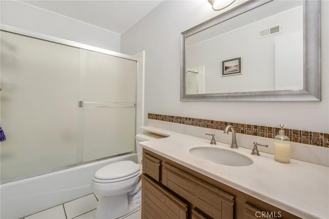 full bathroom featuring tile patterned flooring, vanity, toilet, and combined bath / shower with glass door