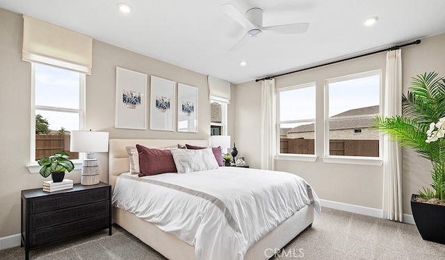 carpeted bedroom with multiple windows and ceiling fan