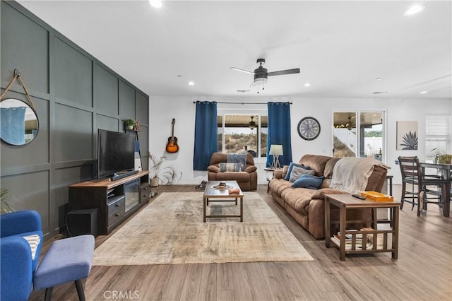 living room featuring ceiling fan and light hardwood / wood-style flooring