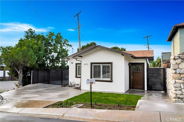 view of front of house with a gate, fence, and stucco siding