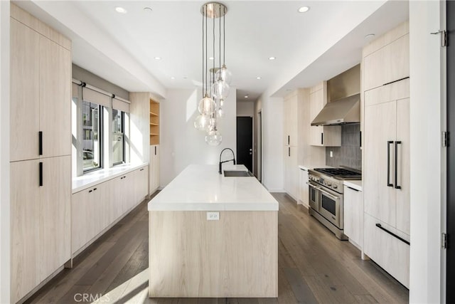 kitchen featuring sink, light brown cabinets, double oven range, dark hardwood / wood-style floors, and hanging light fixtures