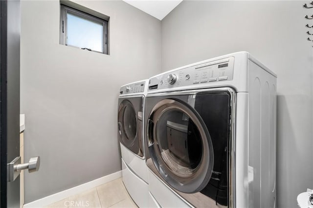 clothes washing area with washer and clothes dryer and light tile patterned floors