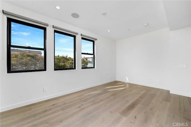 unfurnished room featuring light wood-type flooring and a wealth of natural light