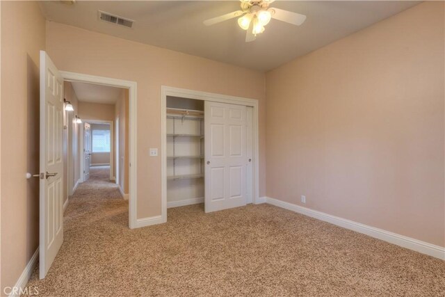 unfurnished bedroom featuring light colored carpet, a closet, and ceiling fan