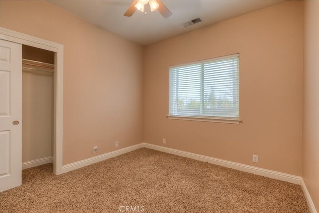 unfurnished bedroom with a closet, ceiling fan, and carpet