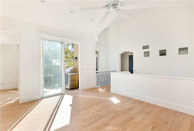 spare room featuring ceiling fan, high vaulted ceiling, and light hardwood / wood-style flooring