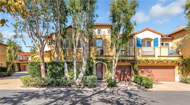 mediterranean / spanish home featuring a balcony and a garage