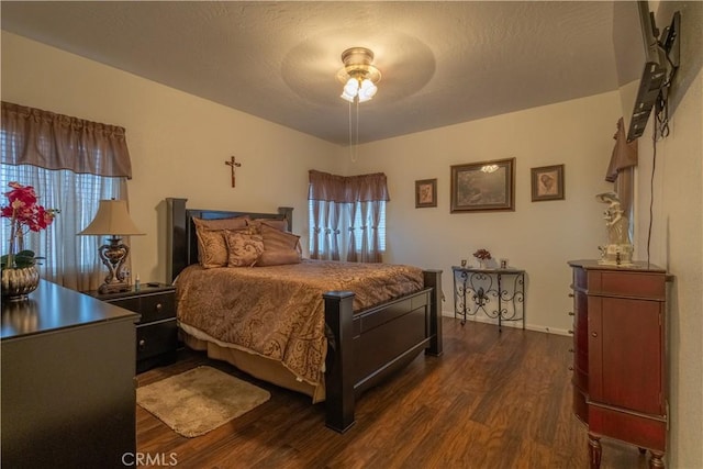 bedroom featuring a textured ceiling, ceiling fan, and dark wood-type flooring