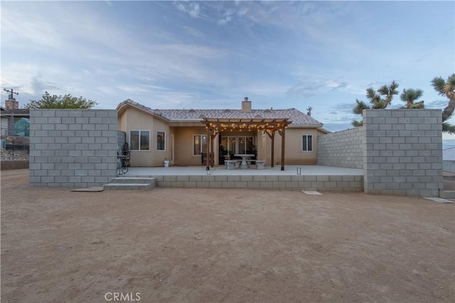 back of property with a pergola and a patio