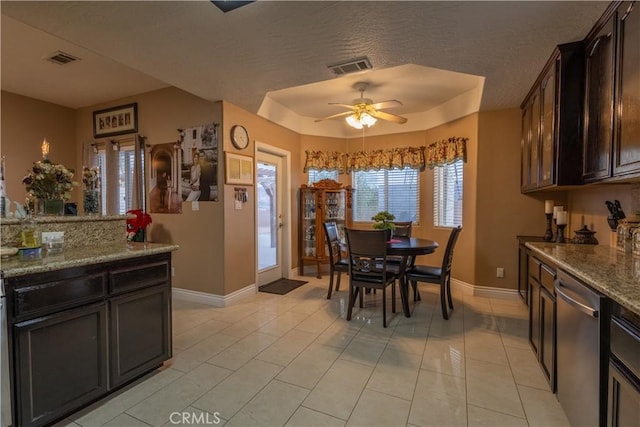 tiled dining area with a textured ceiling and ceiling fan