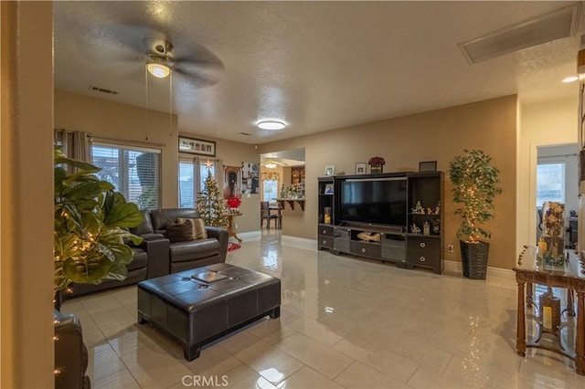 living room featuring a textured ceiling and ceiling fan