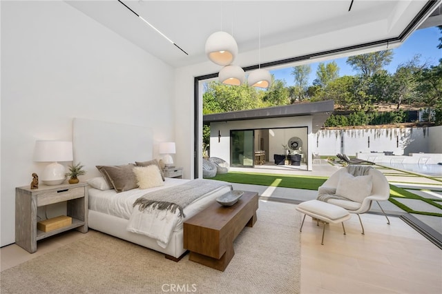 bedroom featuring a water view and light wood-type flooring