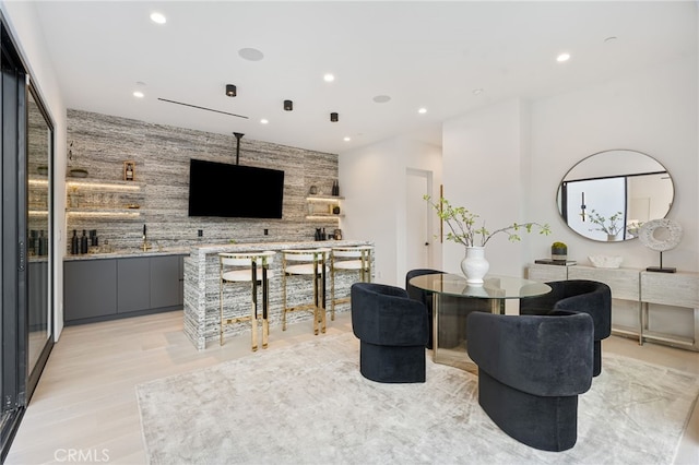 dining space featuring light hardwood / wood-style floors and indoor bar