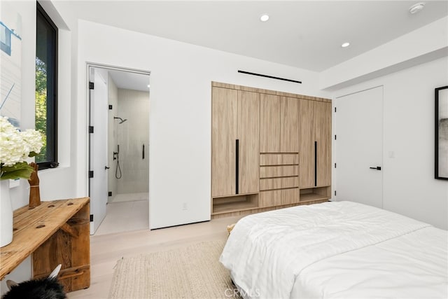 bedroom featuring light hardwood / wood-style flooring and ensuite bath