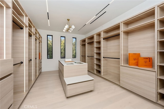 spacious closet featuring a notable chandelier