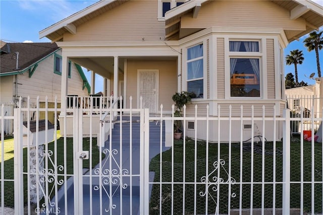 bungalow-style home featuring a fenced front yard, crawl space, covered porch, and a gate