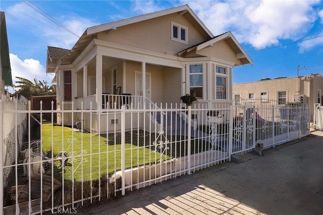 view of front of property with a front yard, fence private yard, and covered porch