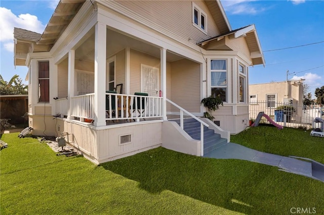 view of property exterior with a porch and a lawn