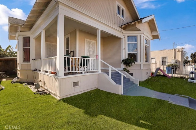 exterior space with crawl space, a porch, a front lawn, and fence