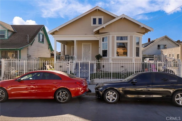bungalow-style house featuring a fenced front yard and covered porch