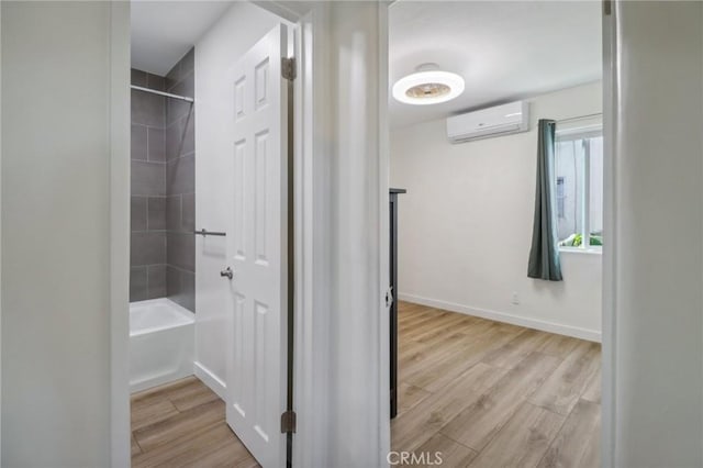 corridor featuring light hardwood / wood-style floors and an AC wall unit