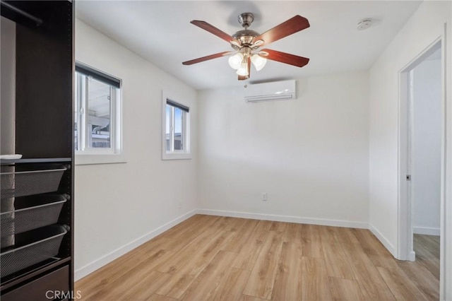 empty room with ceiling fan, light hardwood / wood-style floors, and an AC wall unit