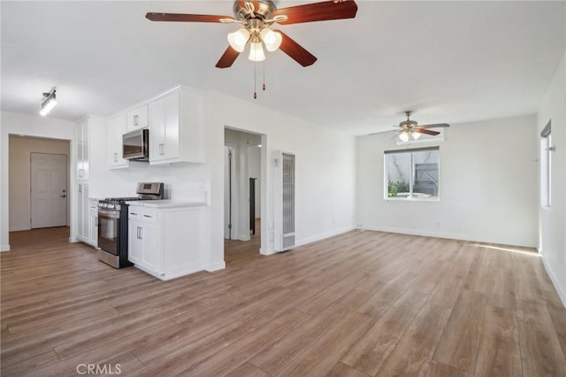 kitchen featuring white cabinets, stainless steel appliances, and light hardwood / wood-style flooring