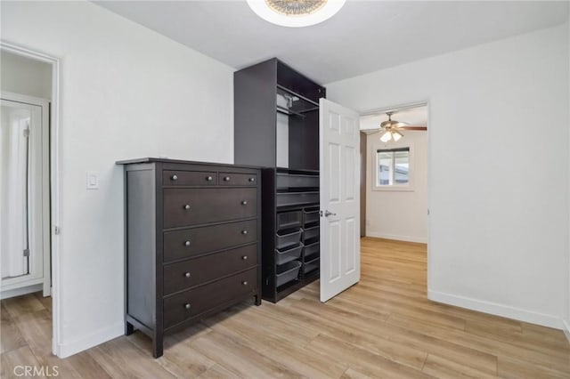 spacious closet with ceiling fan and light hardwood / wood-style flooring