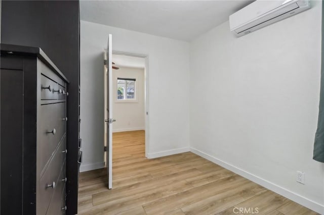 interior space with a wall mounted air conditioner and light wood-type flooring