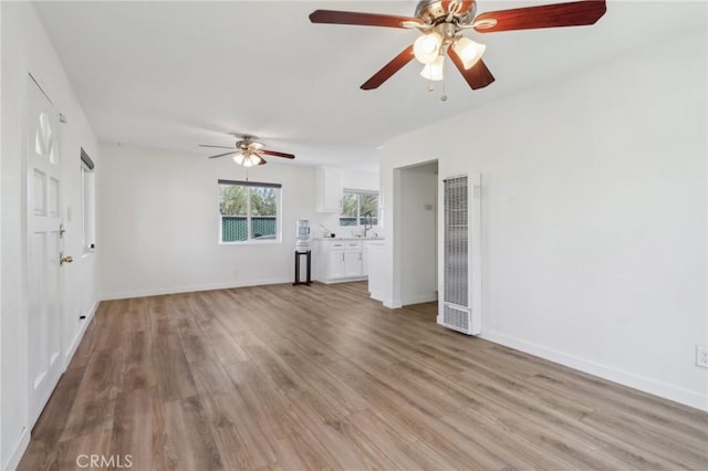 unfurnished living room featuring light hardwood / wood-style flooring and sink