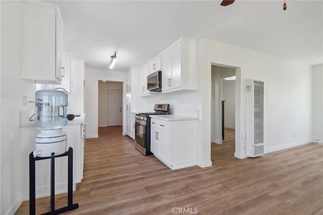 kitchen featuring white cabinetry, light hardwood / wood-style floors, and appliances with stainless steel finishes