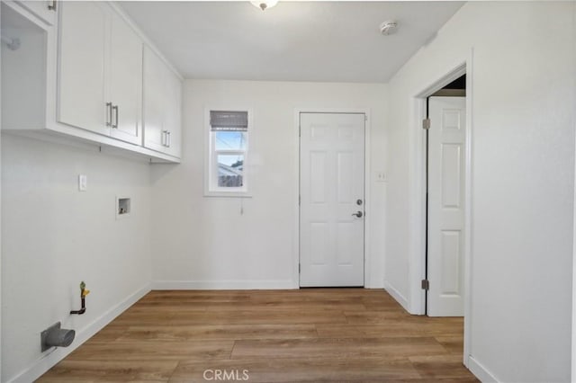 washroom with cabinets, hookup for a washing machine, and light hardwood / wood-style floors