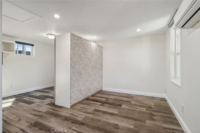 basement with dark hardwood / wood-style flooring and a wall mounted air conditioner