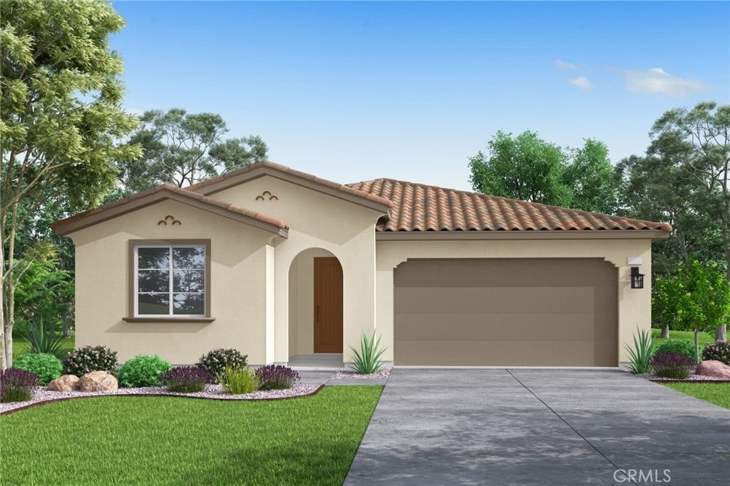 mediterranean / spanish-style house featuring a garage and a front lawn