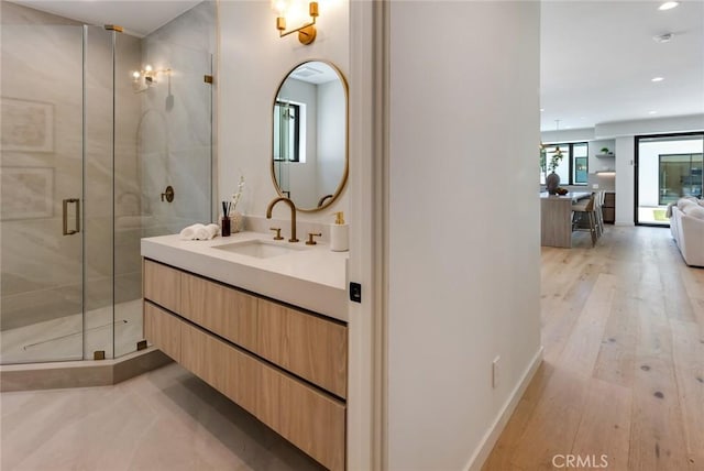 bathroom with hardwood / wood-style floors, vanity, and walk in shower