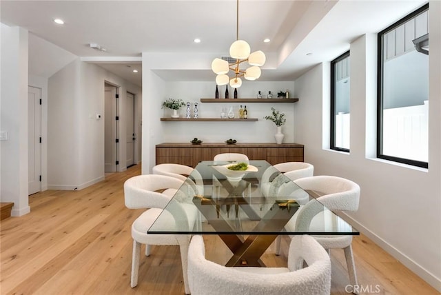 dining space featuring bar and light wood-type flooring