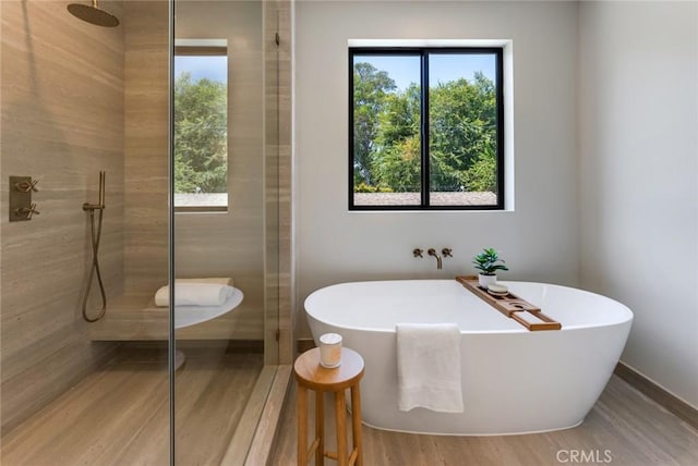 bathroom featuring separate shower and tub and wood-type flooring