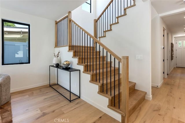 stairway featuring hardwood / wood-style flooring and a wealth of natural light