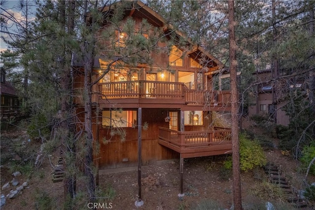 back house at dusk with a deck