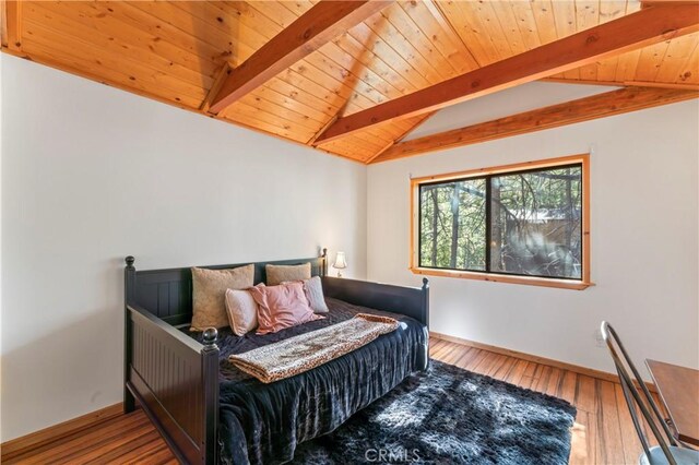 bedroom featuring hardwood / wood-style floors, vaulted ceiling with beams, and wood ceiling