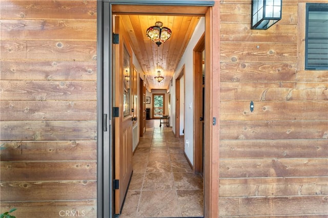 hallway featuring wood walls and wooden ceiling