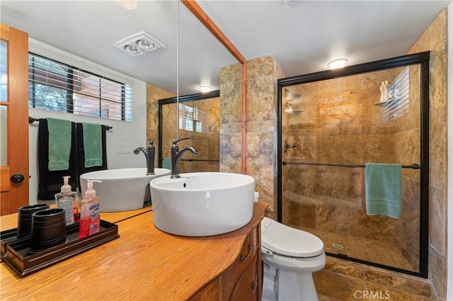 bathroom with tile patterned floors, toilet, vanity, and walk in shower