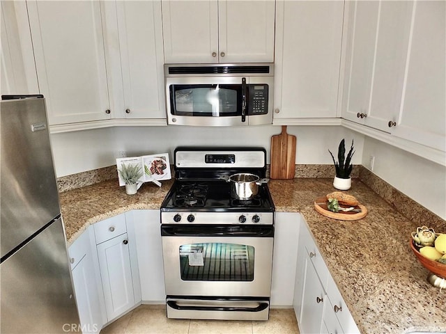 kitchen featuring light stone countertops, white cabinets, and stainless steel appliances